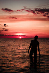 A man on the sea against the sunset. Red sunset
