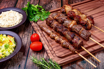 Kebab - Grilled meat on a cutting board, with flour and vinaigrette salad