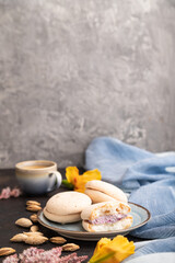 Meringues cakes with cup of coffee on a black concrete background. Side view, selective focus, copy space.