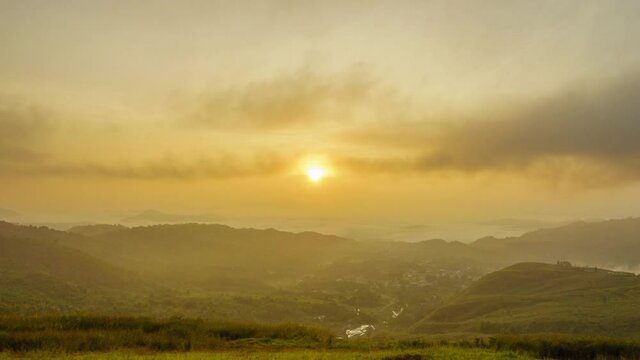 Beautiful golden sunrise with fast rolling clouds drifting over the village. Taken at RANAU, SABAH , BORNEO. time lapse motion tilt down