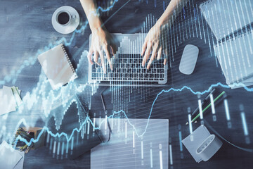 Multi exposure of woman hands working on computer and forex chart hologram drawing. Top View. Financial analysis concept.