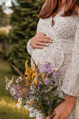 Young pregnant woman with flowers