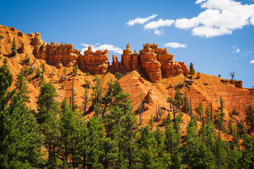 Red Canyon NM showing red clay and sandstone with blue sky and white clouds
