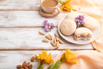 Meringues cakes with cup of coffee on a white wooden background. Side view, copy space.