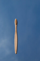 Light bamboo toothbrushes are reflected in the mirror against the blue sky. Oral cavity care and protection