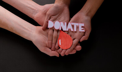 Hands holding a drop of blood, blood donation, blood transfusion, world blood donor day, world hemophilia day concept