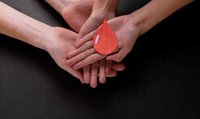 Hands holding a drop of blood, blood donation, blood transfusion, world blood donor day, world hemophilia day concept