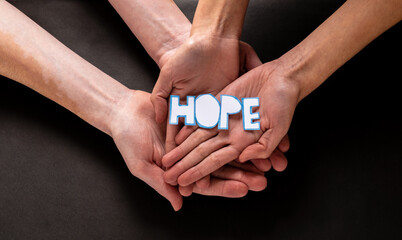 Over HOPE hands on heald background, Alzheimer's disease, pancreatic cancer, epilepsy awareness, domestic violence awareness