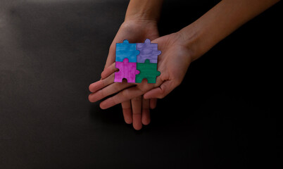 Hands with puzzle pieces, business strategy planning, Alzheimer's disease, autism and mental...