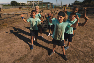 Group of kids flexing their biceps at a boot camp