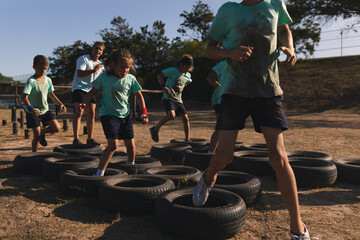 Group of kids walking through tires during obstacle course at a boot camp