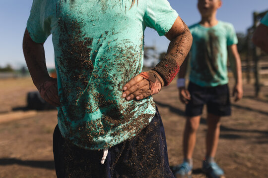 Mid section of boy standing with hands on his hips at a boot camp