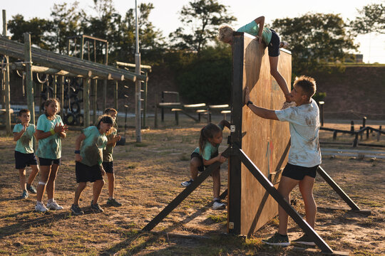 Kids climbing over a obstacle course at a boot camp - Powered by Adobe