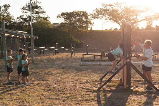 Boys climbing over a obstacle course at a boot camp