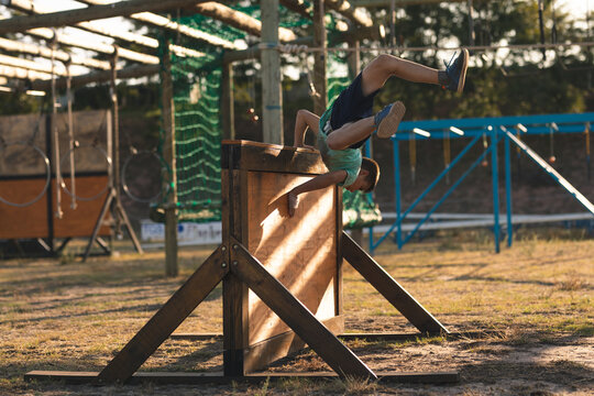 Boy jumping over a hurdle during obstacle course at a boot camp