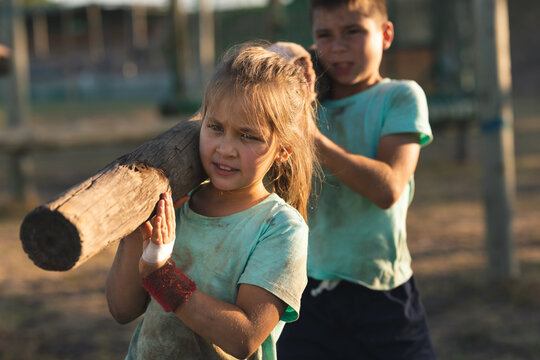 Kids carrying a log at a boot camp