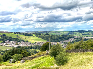 Fototapeta na wymiar Looking toward Haworth, from the moor top, with grass, houses and trees in, Haworth, Keighley, UK