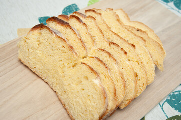 Delicious and healthy - Traditional Brazilian corn bread sliced on a cutting board. Isolated on floral background. Close-up.