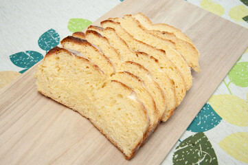 Delicious and healthy - Traditional Brazilian corn bread sliced on a cutting board. Isolated on floral background. Top view. Close-up. Copy space.