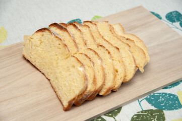 Delicious and healthy - Traditional Brazilian corn bread sliced on a cutting board. Isolated on floral background. Top view. Copy space.