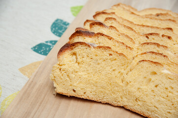 Delicious and healthy - Traditional Brazilian corn bread sliced on a cutting board. Isolated on floral background. Copy space.