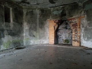 Crumbling brick fireplace in spooky military bunker.