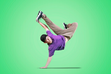 Male dancer showing break dance movement on studio - obrazy, fototapety, plakaty