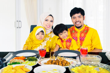 Smiling family celebrate eid mubarak in dining room
