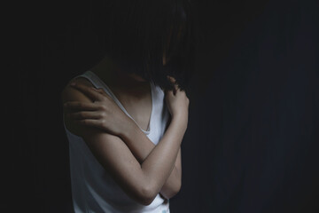 Portrait of sad little girl standing on black background, fear child, . human trafficking concept.