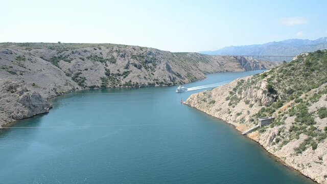 Panoramic view on sea canal. Tourist boat on Adriatic Sea. View on Maslenica strait from the Maslenica Bridge, Dalmatia, Croatia. Ship on the water.