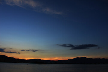 Fototapeta na wymiar 湖の対岸の夕日