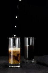 glass of coffee with milk splash on dark background