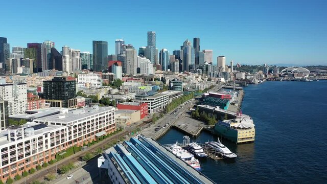 Drone footage of the cruise terminal and nearby piers in Seattle downtown, waterfront, empty Alaskan Way with skyscrapers, during the pandemic