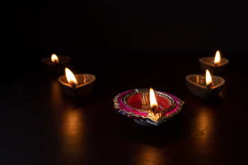 Decorative colourful diya lamps lit during diwali festival. 