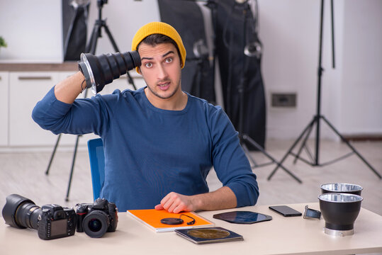 Young male photographer working in the studio