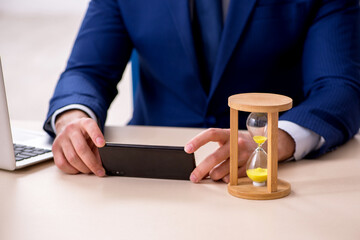 Young male employee in time management concept