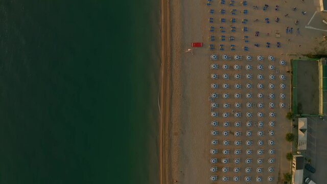 Bird&rsquo;s Eye view moving forward shot, Beach chairs on the sandy beach of Sirolo, Italy, Scenic view of the Adriatic Sea in the background.