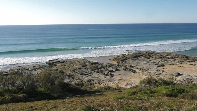 Beautiful blue waves rolling to the rocky beach - Buddina Port Cartwright Lighthouse - Sunshine Coast Australia - Slow motion