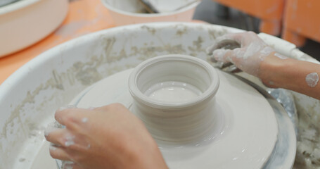 Making ceramic pot on turning pottery wheel