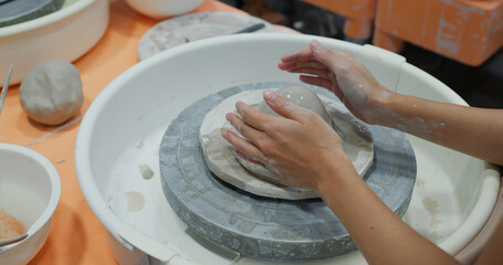 Hand work on pottery wheel, shaping a clay pot