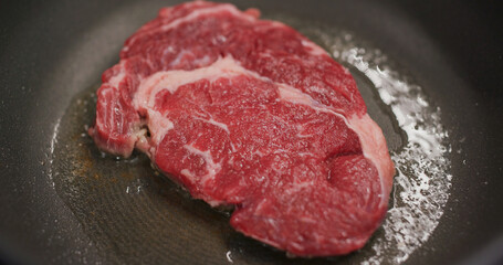 Fried steak on the pan in kitchen