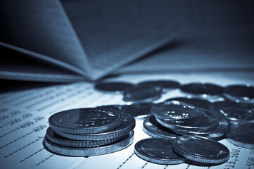 coins on savings account passbook for finance and banking concept abstract blue background