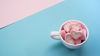 Pile of colorful pink heart marshmallows in cup top view