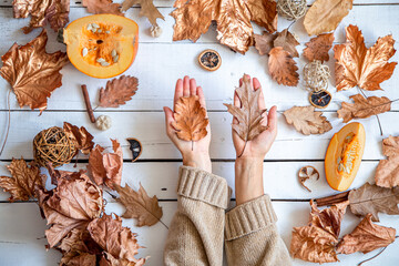 Autumn composition with dry leaves and women's hands