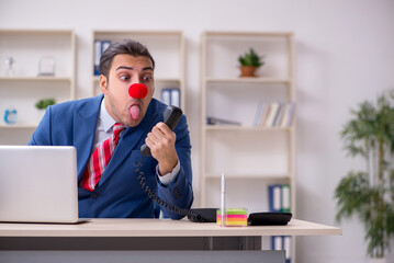 Funny employee clown working in the office