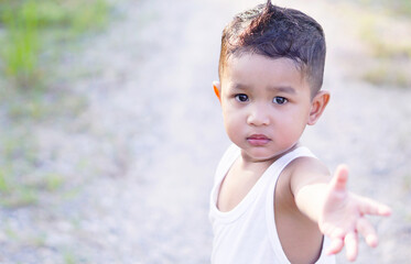 Portrait of cute happy Asian boy Wearing a yellow t-shirt. Close-up of smiley face little kid 2 year old outdoor concept.