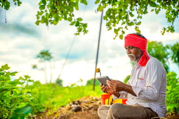 Indian farmer using mobile phone at Agriculture field