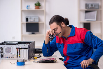 Young male repairman repairing computer