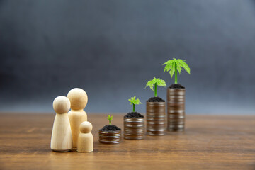 Piles of coins are stacked in a graph shape with family symbol and sapling of a growing tree for money saving ideas and financial planning insurance.