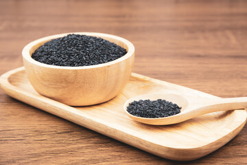 Black sesame seeds in a wooden spoon For healthy food and diet concepts.